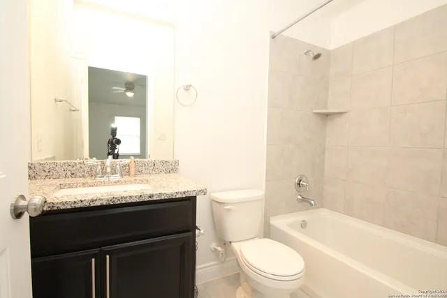 a bathroom with a granite countertop sink toilet and shower