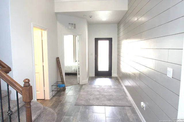 a view of a hallway with furniture and a window