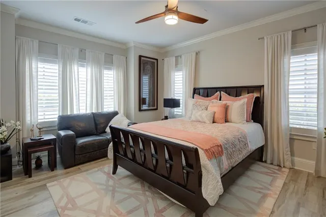 a bedroom with a bed couch and windows