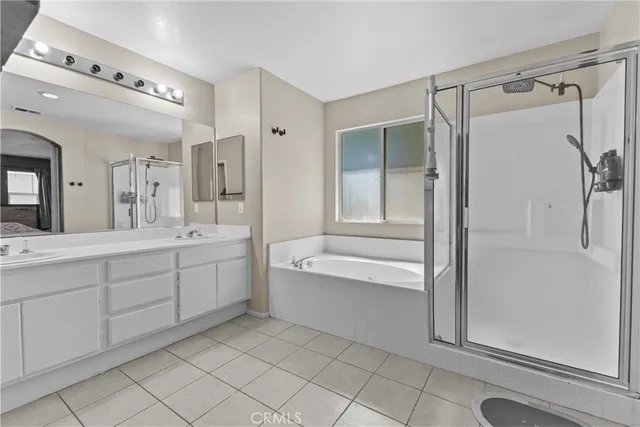 a spacious bathroom with a shower a sink and a mirror