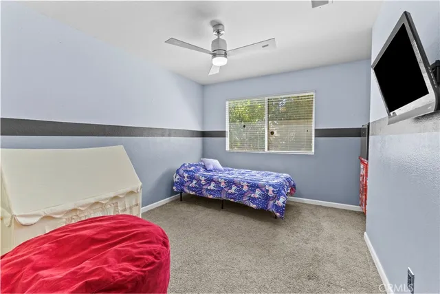 a bedroom with a bed and a flat tv screen on the dresser