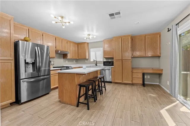 a kitchen with kitchen island wooden floors white appliances and cabinets