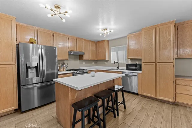 a kitchen with kitchen island a refrigerator stove and microwave