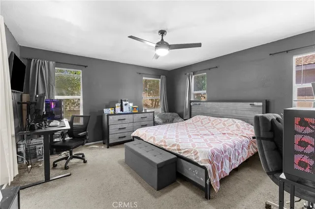 a bedroom with a bed a dresser and a chandelier