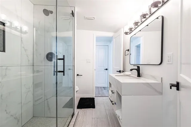 a bathroom with a sink a toilet and shower