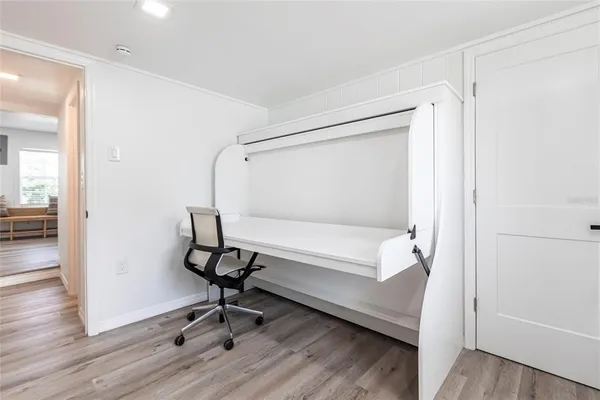 a view of a room with wooden floor table and chairs