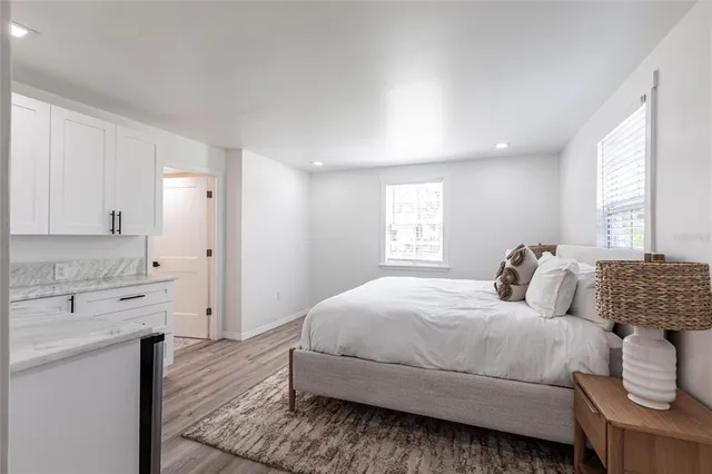 a bedroom with a large bed and wooden floor