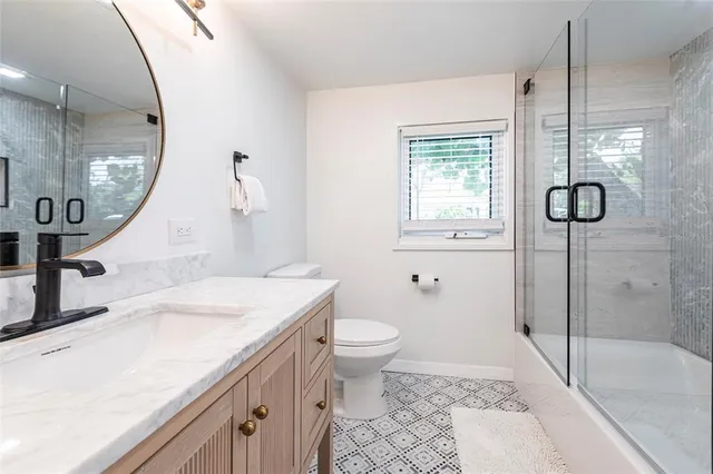 a bathroom with a sink a toilet and a mirror