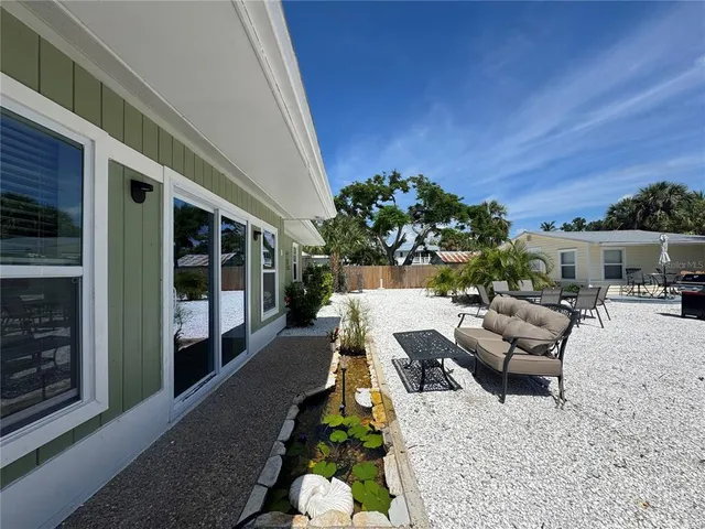 a view of a patio with couches table and chairs and potted plants