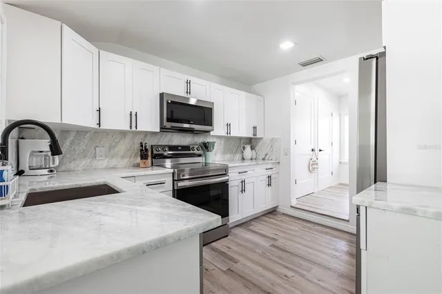 a kitchen with sink a stove and refrigerator