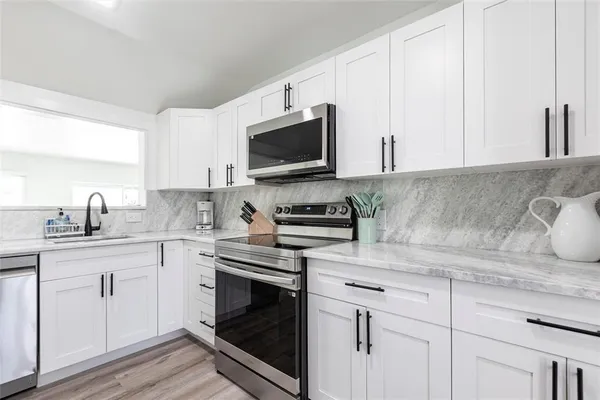 a kitchen with cabinets stainless steel appliances and a sink