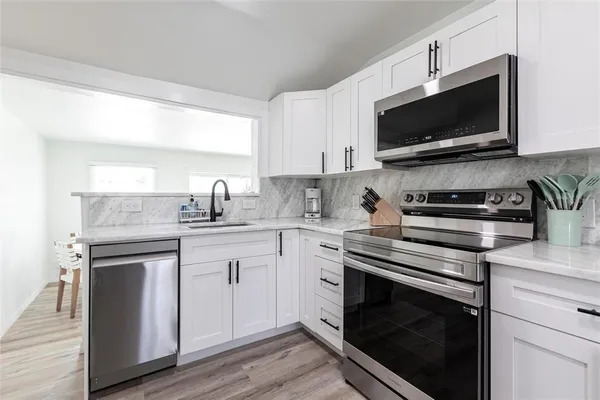 a kitchen with a sink stove and microwave