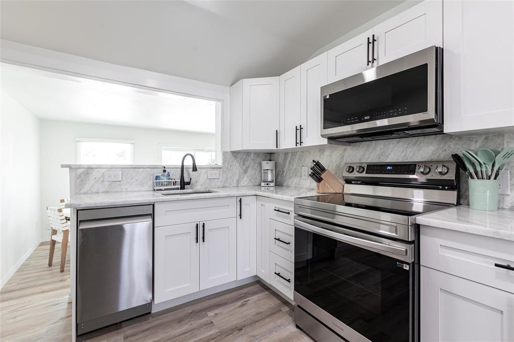 640 Broadway Street Longboat Key, FL 34228 - Photo 10 of 26 a kitchen with a sink stove and microwave