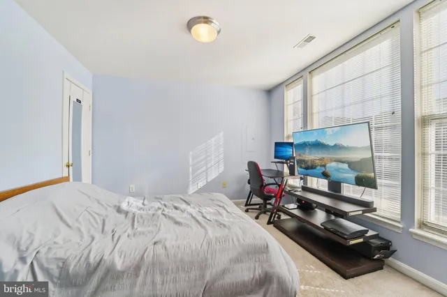 a bedroom with a bed window and a flat screen tv