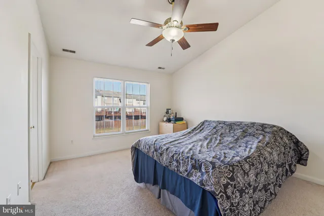 a bedroom with a bed next to a window and a chandelier