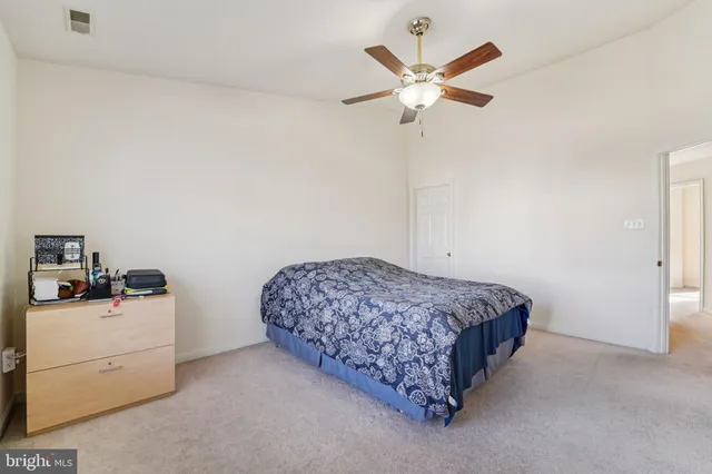 a bedroom with a bed and a ceiling fan
