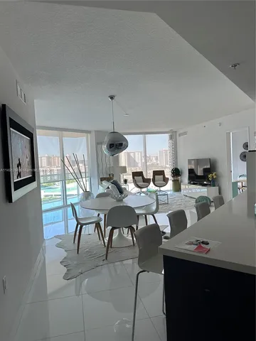 a living room with furniture a flat screen tv and a large window