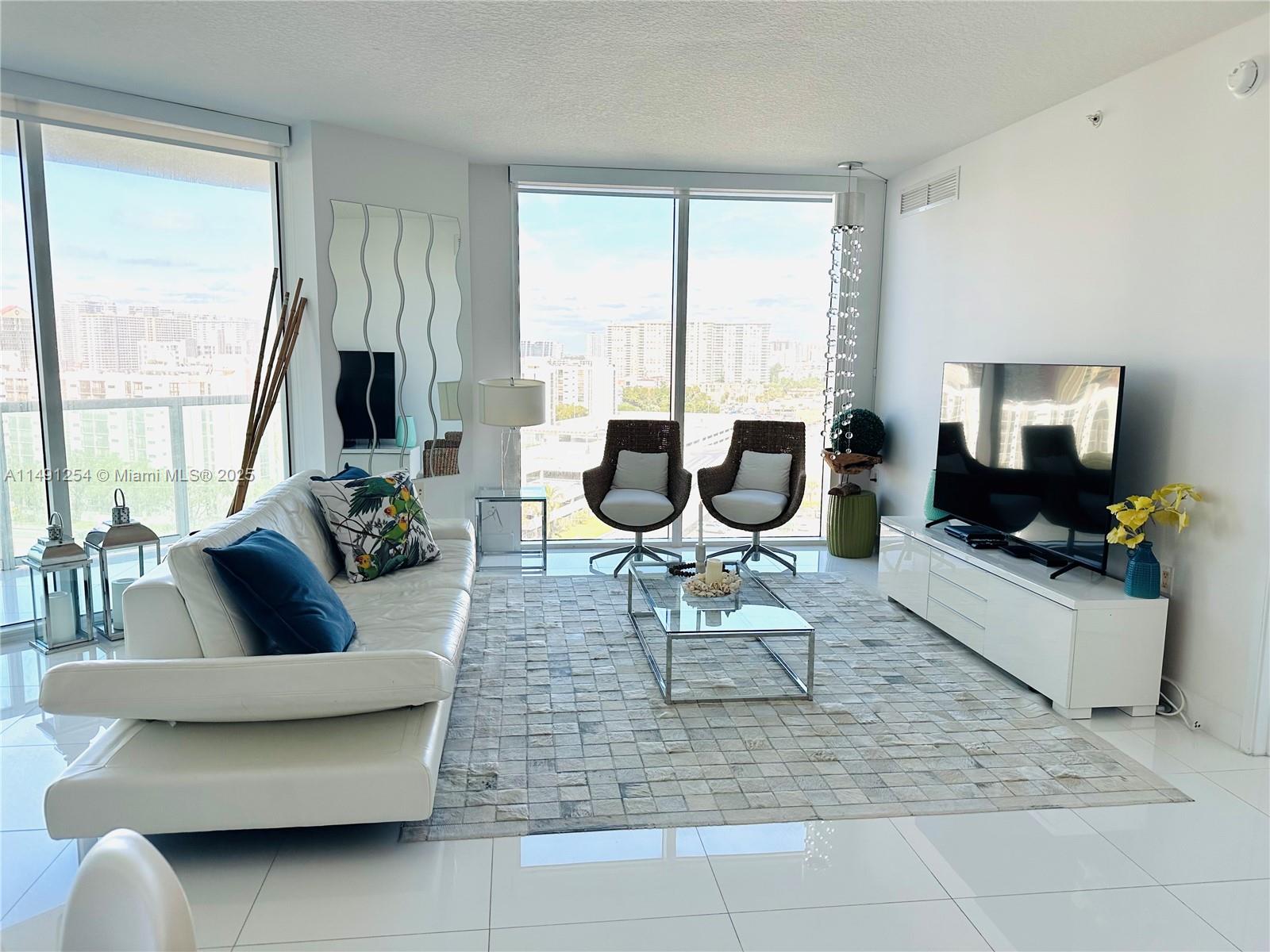 150 Sunny Isles Boulevard, Unit 11102 Sunny Isles Beach, FL 33160 - Photo 3 of 18 a living room with furniture and a large window