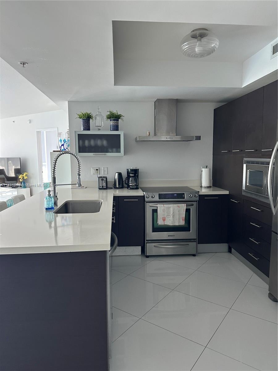 150 Sunny Isles Boulevard, Unit 11102 Sunny Isles Beach, FL 33160 - Photo 4 of 18 a kitchen with kitchen island granite countertop a sink stove and cabinets