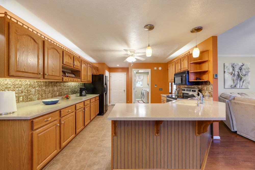 1303 Abiff Road Bon Aqua, TN 37025 - Photo 14 of 50 a kitchen with stainless steel appliances granite countertop a sink a stove top oven a chimney wooden cabinets and glass door