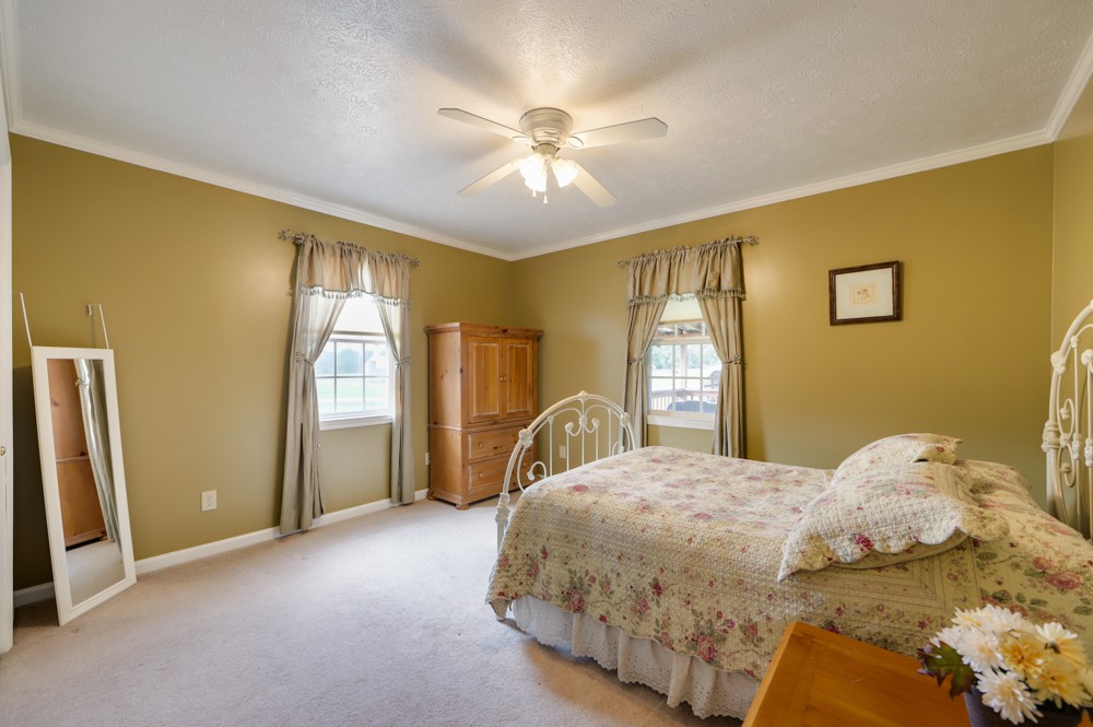 1303 Abiff Road Bon Aqua, TN 37025 - Photo 25 of 50 a bedroom with a bed and a chandelier