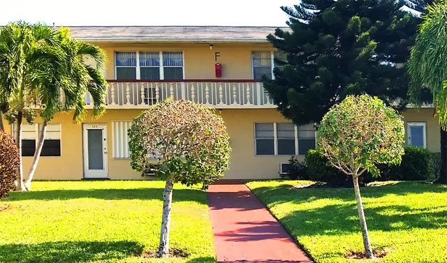 a view of a tennis ground with large trees