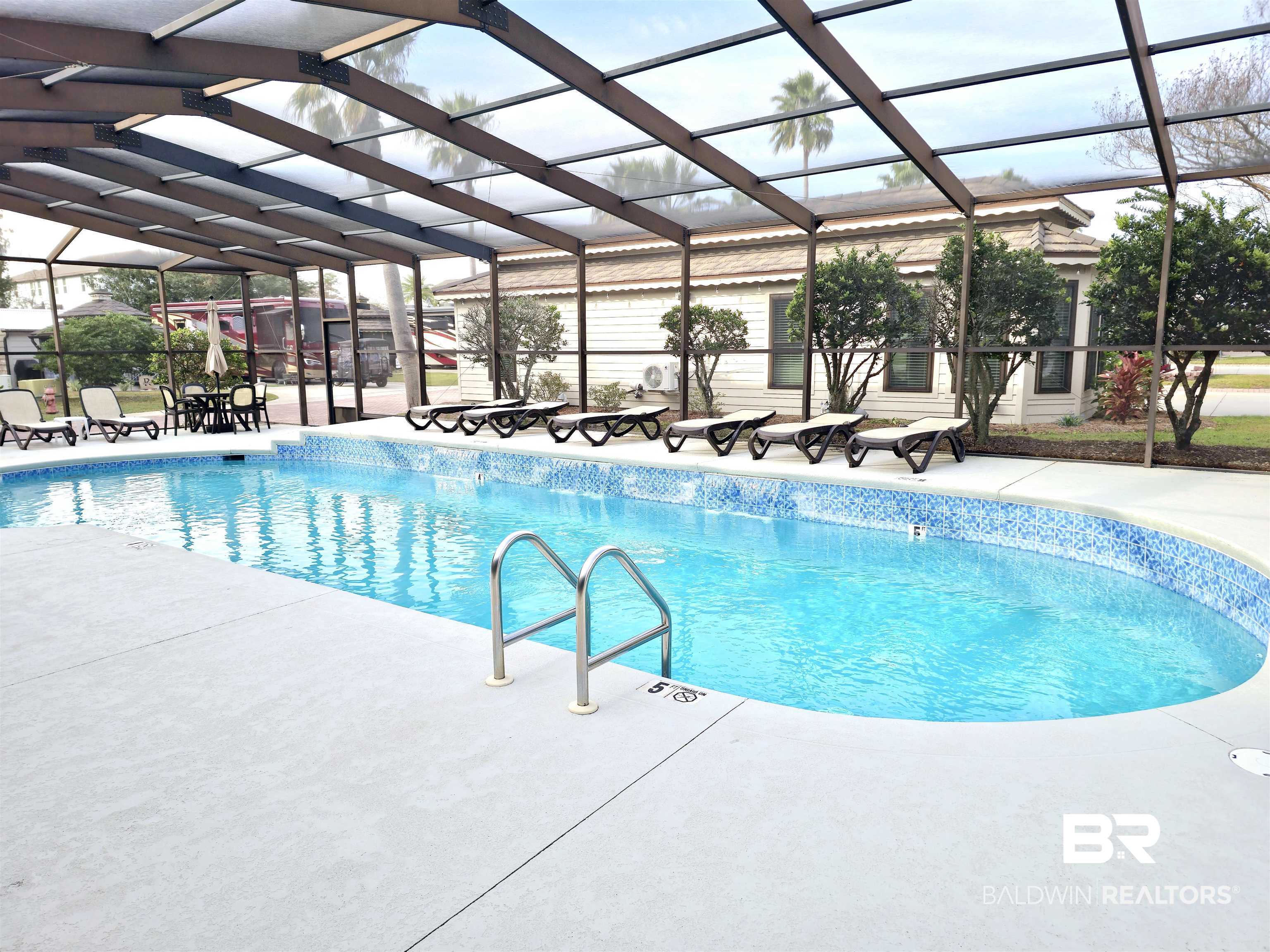 4650 Griffith Marina Road, Unit 12 Orange Beach, AL 36561 - Photo 17 of 34 Community pool with screen enclosure and a patio area