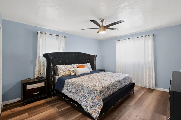 a bedroom with a bed and wooden floor