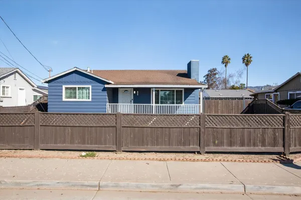 a view of a house with a wooden fence