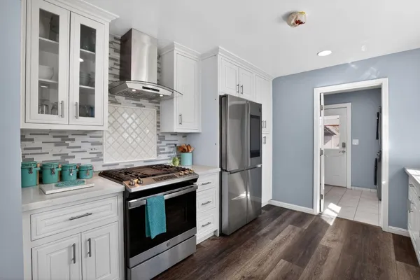 a kitchen with granite countertop a refrigerator and a stove top oven