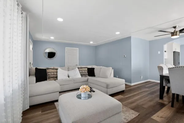 a living room with furniture and a wooden floor