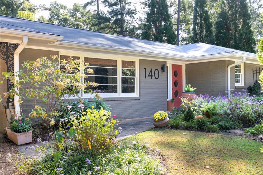 140 Spring Drive Roswell, GA 30075 - Photo 1 of 1 a front view of a house with lots of flowers and trees
