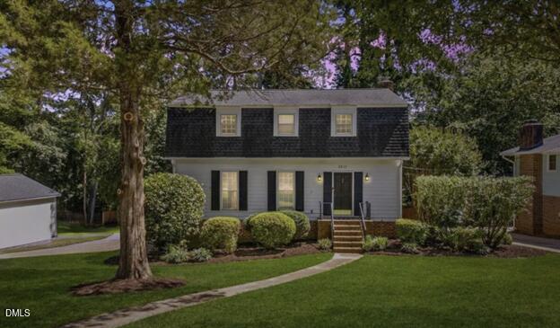 a front view of a house with a yard and trees