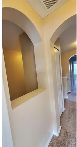 a view of a hallway with wooden floor and a living room