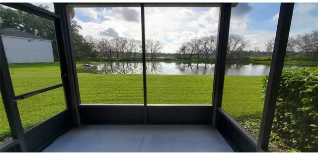 a view of a lake with a yard and large trees