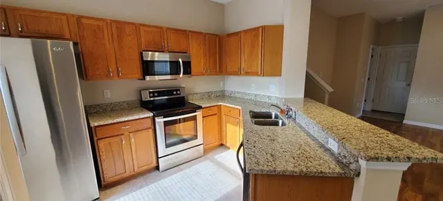 a kitchen with stainless steel appliances granite countertop a refrigerator stove and microwave