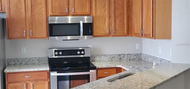 a kitchen with a sink a stove and cabinets