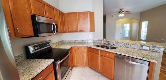 a kitchen with stainless steel appliances granite countertop a sink stove and microwave