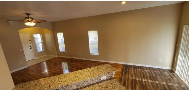 a view of a hallway with wooden floor and chandelier