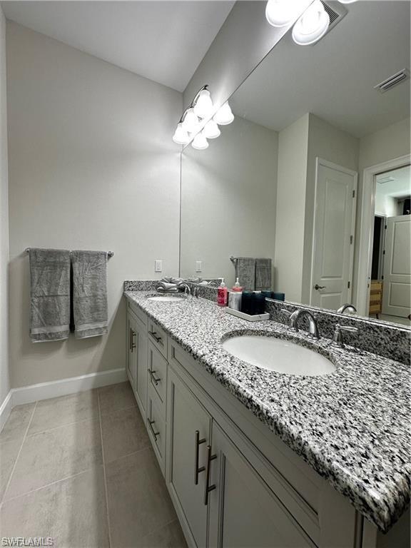 7135 Cayo Coco Lane Naples, FL 34113 - Photo 16 of 41 Bathroom featuring double vanity and light tile patterned flooring