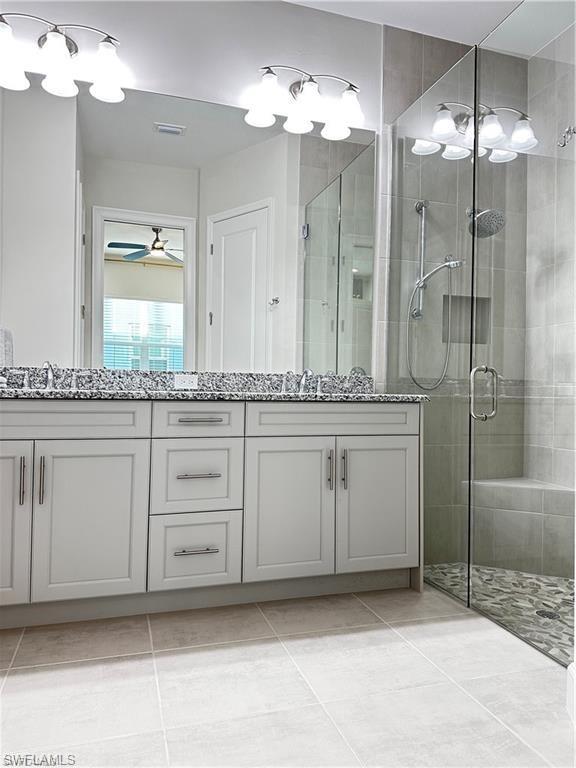 7135 Cayo Coco Lane Naples, FL 34113 - Photo 17 of 41 Full bathroom featuring double vanity, a shower stall, and light tile patterned floors