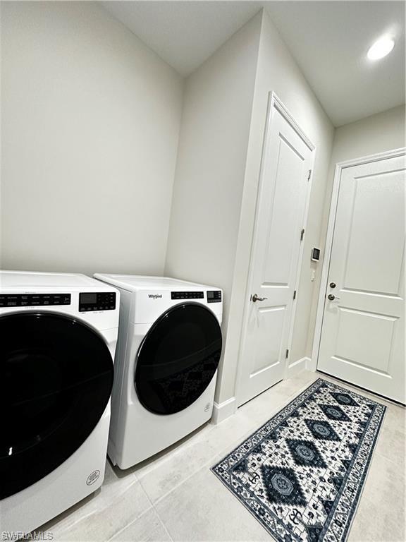 7135 Cayo Coco Lane Naples, FL 34113 - Photo 22 of 41 Laundry area featuring washer and dryer and light tile patterned floors