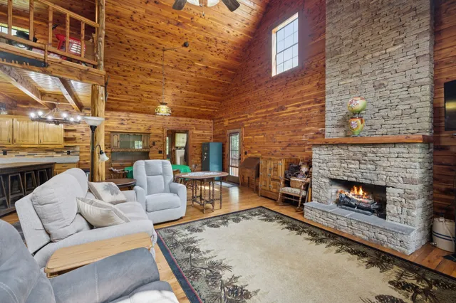 a living room with fireplace furniture and a rug