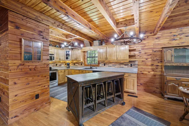a kitchen with stainless steel appliances granite countertop a sink a window and a counter space