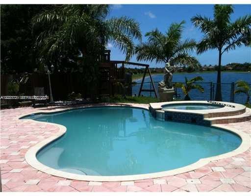 13553 Southwest 124th Avenue Road Miami, FL 33186 - Photo 2 of 31 a view of a swimming pool with a patio