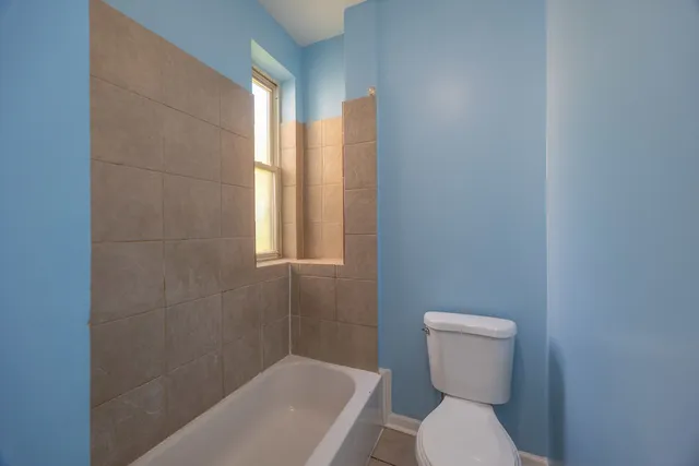 a bathroom with a toilet and a shower