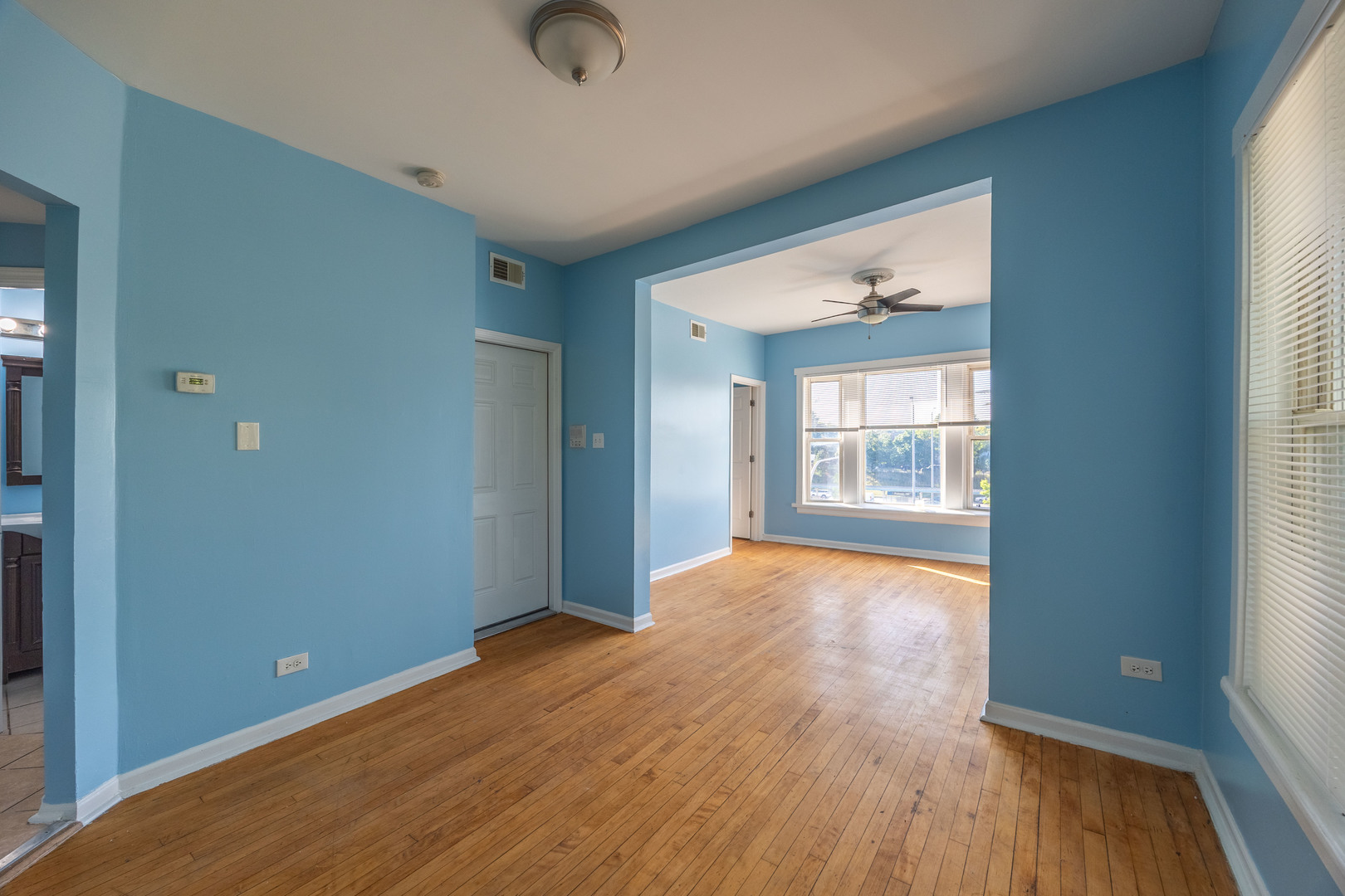 4058 West Congress Parkway, Unit 2S Chicago, IL 60624 - Photo 3 of 13 an empty room with wooden floor and windows