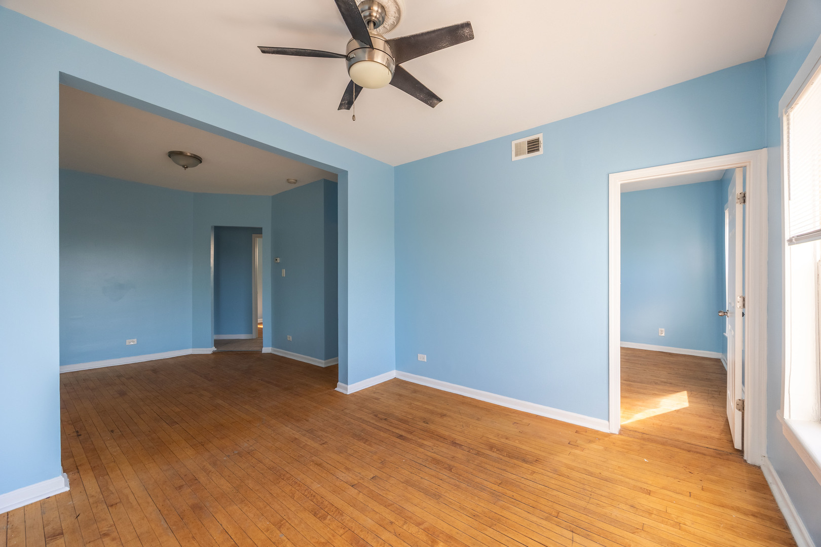 4058 West Congress Parkway, Unit 2S Chicago, IL 60624 - Photo 5 of 13 a view of a big room with wooden floor and a ceiling fan