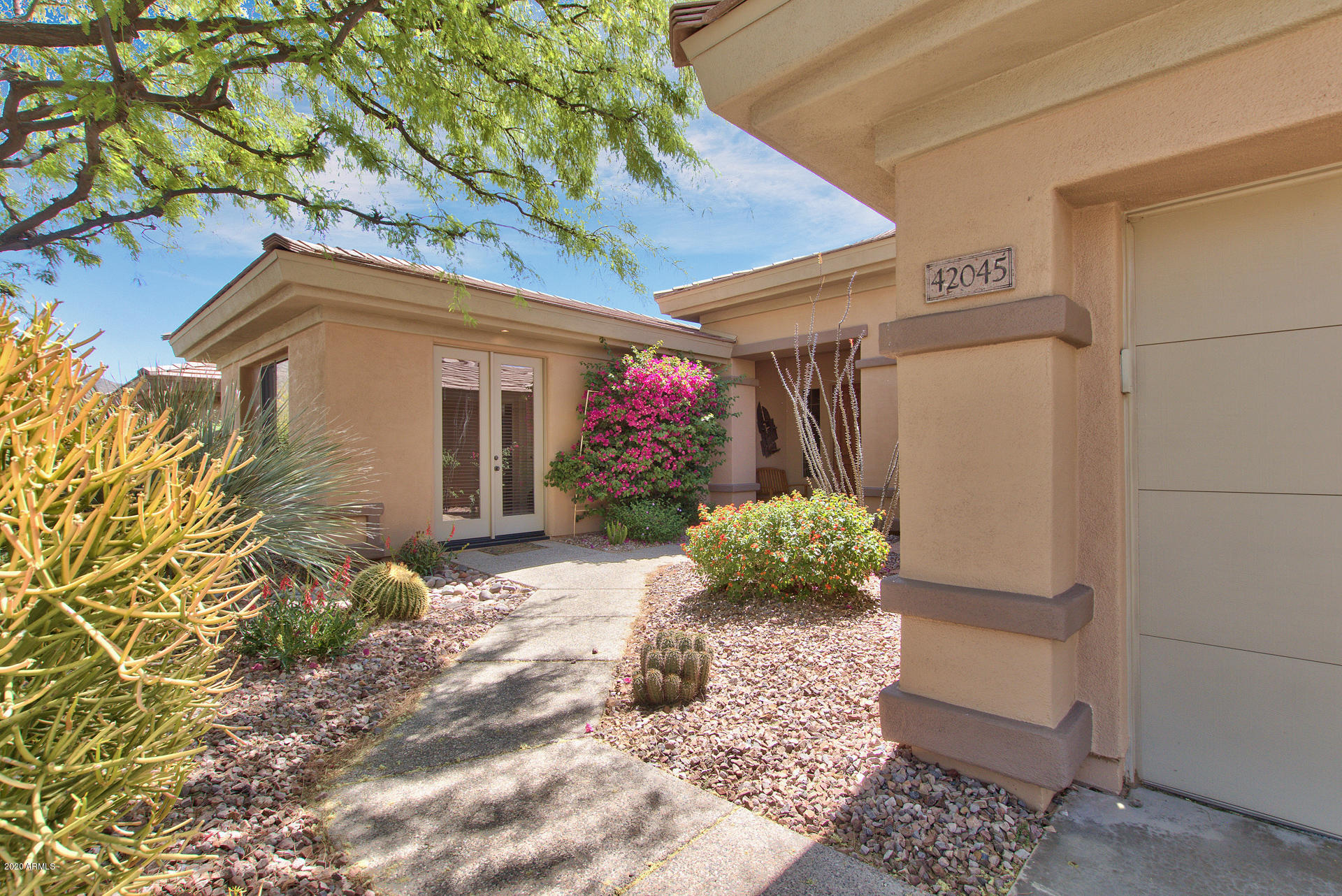 42045 North Crooked Stick Road Anthem, AZ 85086 - Photo 3 of 37 a front view of a house with a yard and a garden