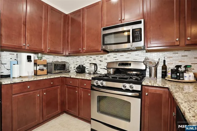 a kitchen with granite countertop wooden cabinets and a stove top oven